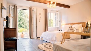 Une chambre à coucher avec un lit, une table de chevet et une vue sur l’extérieur.
