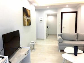 Suite, delvis sjøutsikt | Oppholdsområde | En 32-tommers TV med kabel-kanaler