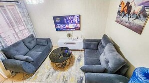 Familienapartment, Stadtblick | Wohnbereich | 32-Zoll-Smart-TV mit Digitalempfang