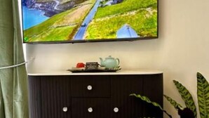 A television mounted on a wall with a decorative shelf below it.