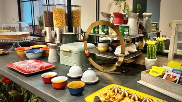 A buffet setup with various food items and serving utensils.