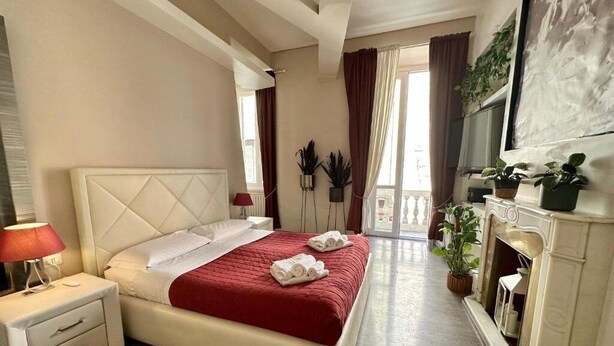 Una habitación de hotel con cama, mesita de noche y chimenea.