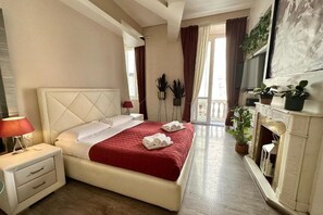Una habitación de hotel con cama, mesita de noche y chimenea.