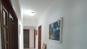 Een hal met een houten bureau, een stoel en een schilderij aan de muur.