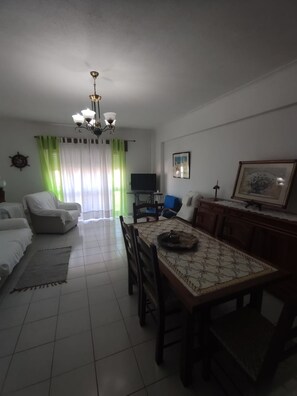 Relax in this spacious living area with a dining table, TV, and comfortable seating.