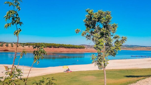 A clear view of a beach with a pool, surrounded by greenery and a clear blue sky. - Ferreira Alentejo Terrace Villa (Ferreira do Alentejo)