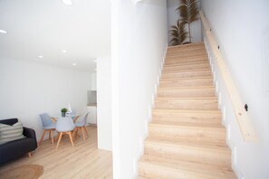 Una sala de estar moderna con una escalera de madera.