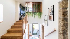 A wooden staircase with a view of a garden and a stone wall. - Quintinha Sao Martinho Luxury 2suites Villa Padrao (Vila do Conde)