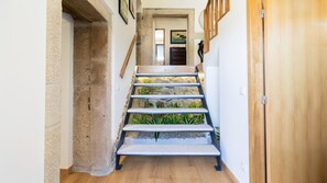Un pasillo estrecho con una escalera de madera que sube a una habitación.