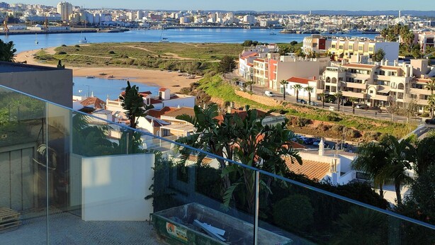 Un paysage urbain côtier offrant une vue sur la mer, des bâtiments et un ciel dégagé.