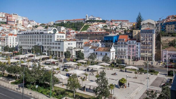 A cityscape with a mix of modern and historic buildings, a central open square, and a hilly backdrop. - Lisboa - Martim Moniz Central Apartment and Garage (Lisbon)