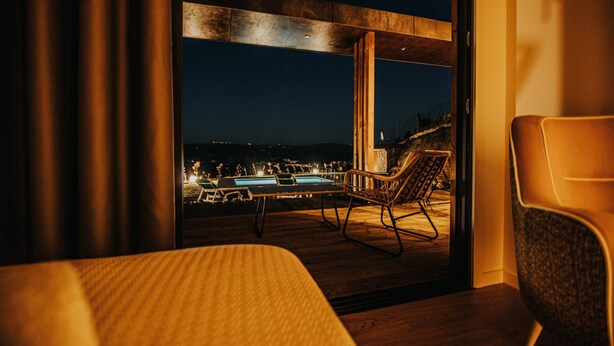 A room with a view of an outdoor pool area at night. - Deluxe Private Pool Bungalow (Celorico de Basto)
