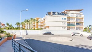 A multi-story hotel with balconies, a roundabout, and palm trees in the background. - Albufeira Terrace Pool Garage Dream Flat (Albufeira)