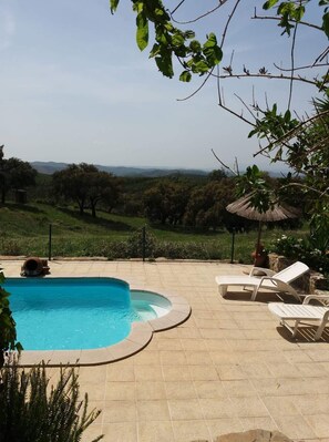 A swimming pool with a view of a hilly landscape.