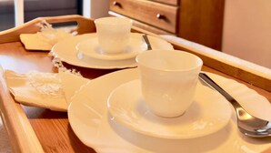 A wooden tray with white cups and saucers, a spoon, and a napkin on a table in a room with a wooden dresser and a mirror. - Nice Flat 150 mt Beach With Garage (Portimão)