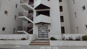 A modern multi-story building with a central staircase, balconies, and a patterned door. - Ground Floor Palmeira Gal Villa With Pool (Albufeira)