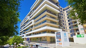 A multi-story building with balconies, a parking sign, and a pharmacy sign. - Superior Garage Balcony Praia da Rocha Prime Flat (Portimão)