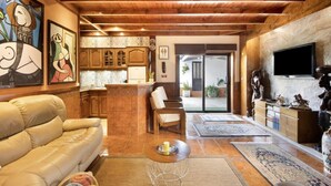 A spacious living area with a wooden ceiling, a sofa, a coffee table, and a television. - Private Pool Villa 20min by Porto (Oliveira De Azemeis)