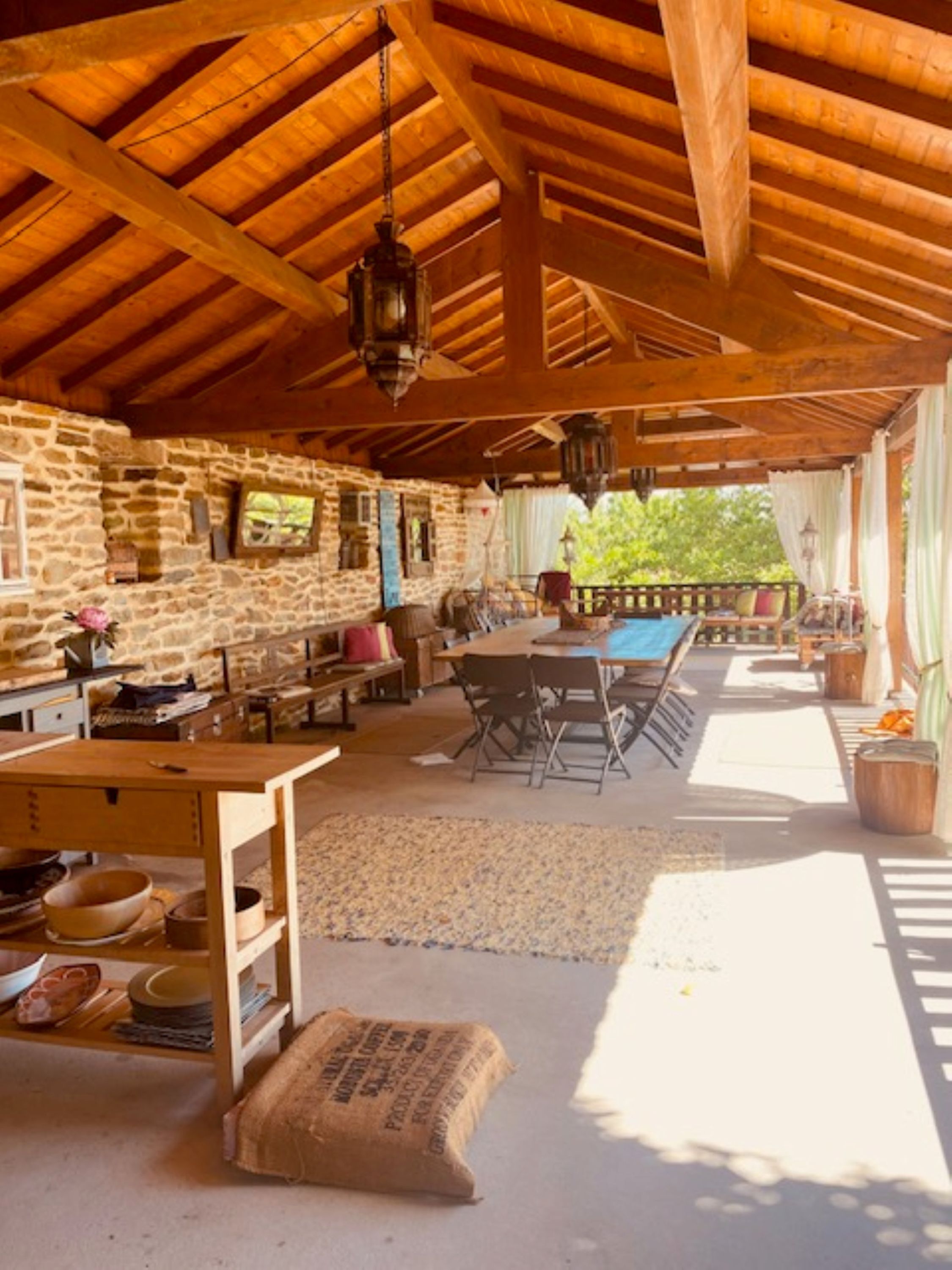 Un interior rústico de madera con paredes de piedra, una mesa de madera y un banco.