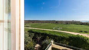 A view from a balcony overlooking a green field and a clear blue sky. - Beach Front View Armacao de Pera Flat (Silves)