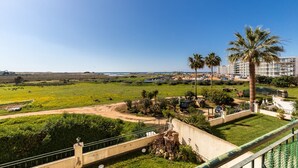 A hotel with a view of a green field and palm trees. - Beach Front View Armacao de Pera Flat (Silves)