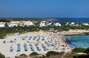 Une station balnéaire dotée de parasols, d’une plage de sable et offrant une vue sur la mer.