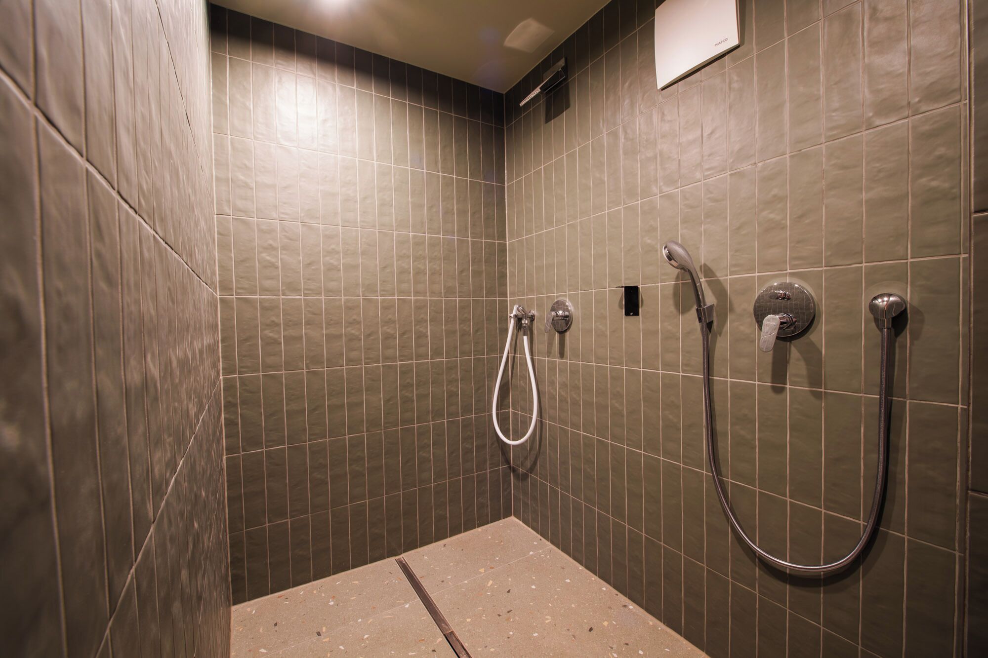 A shower area with tiled walls and a showerhead.