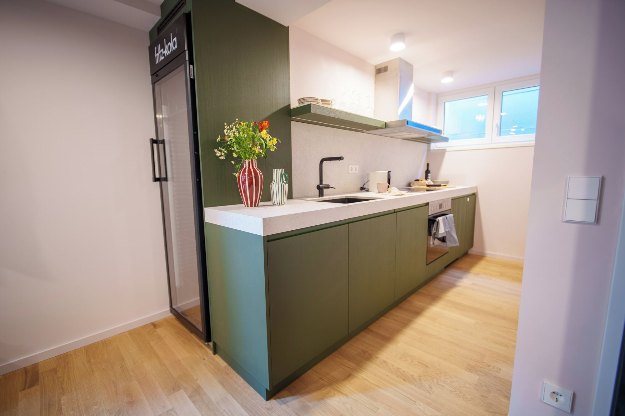 Una cocina compacta con refrigerador incorporado, un lavamanos y una estufa.