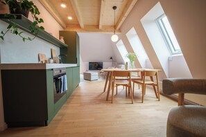 A modern loft apartment with a kitchen, dining area, and living space. - stuub titisee (Titisee-Neustadt)
