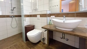 Un baño moderno con ducha, inodoro y lavabo.