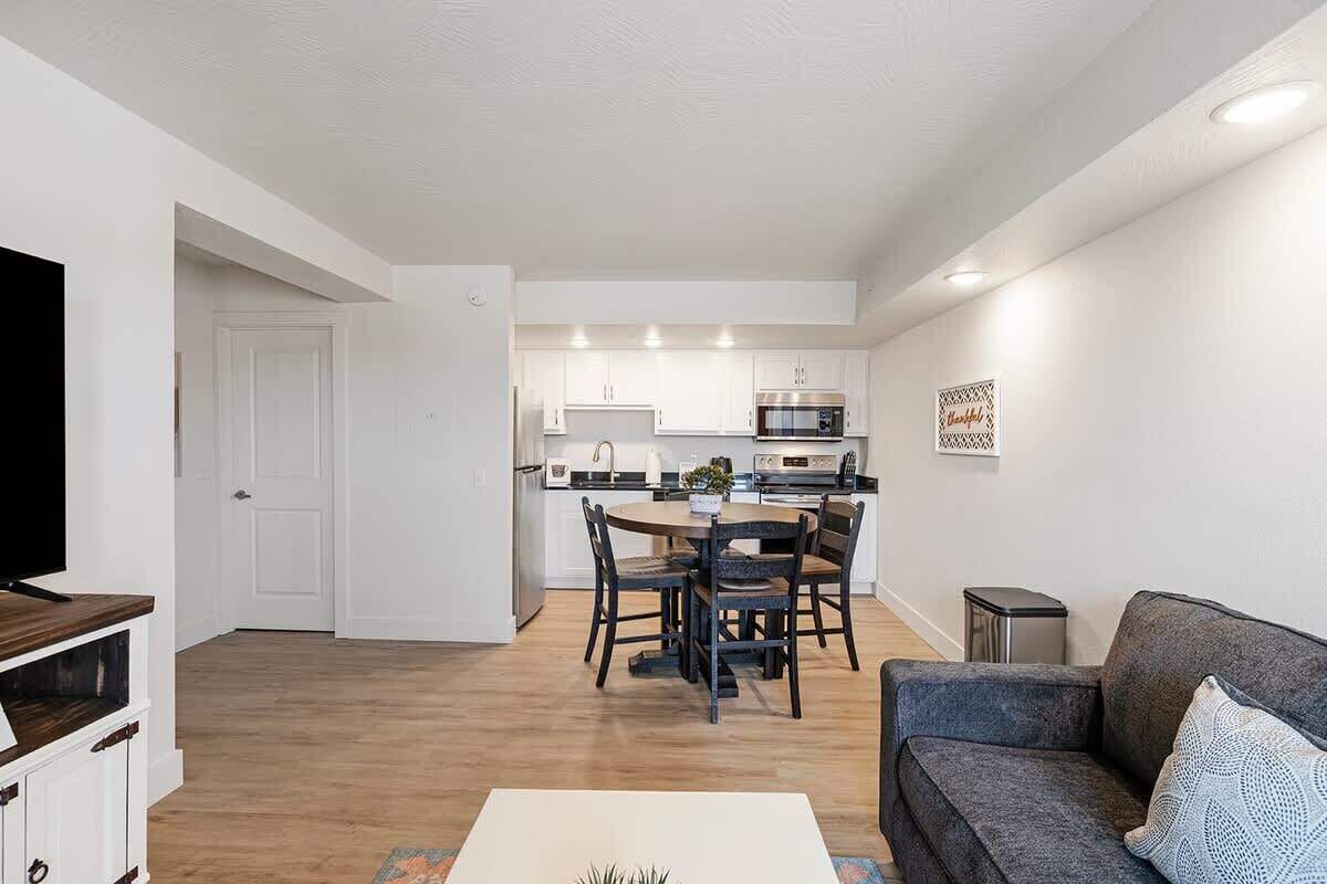 Un appartement moderne comprenant un coin repas, une cuisine et un salon.