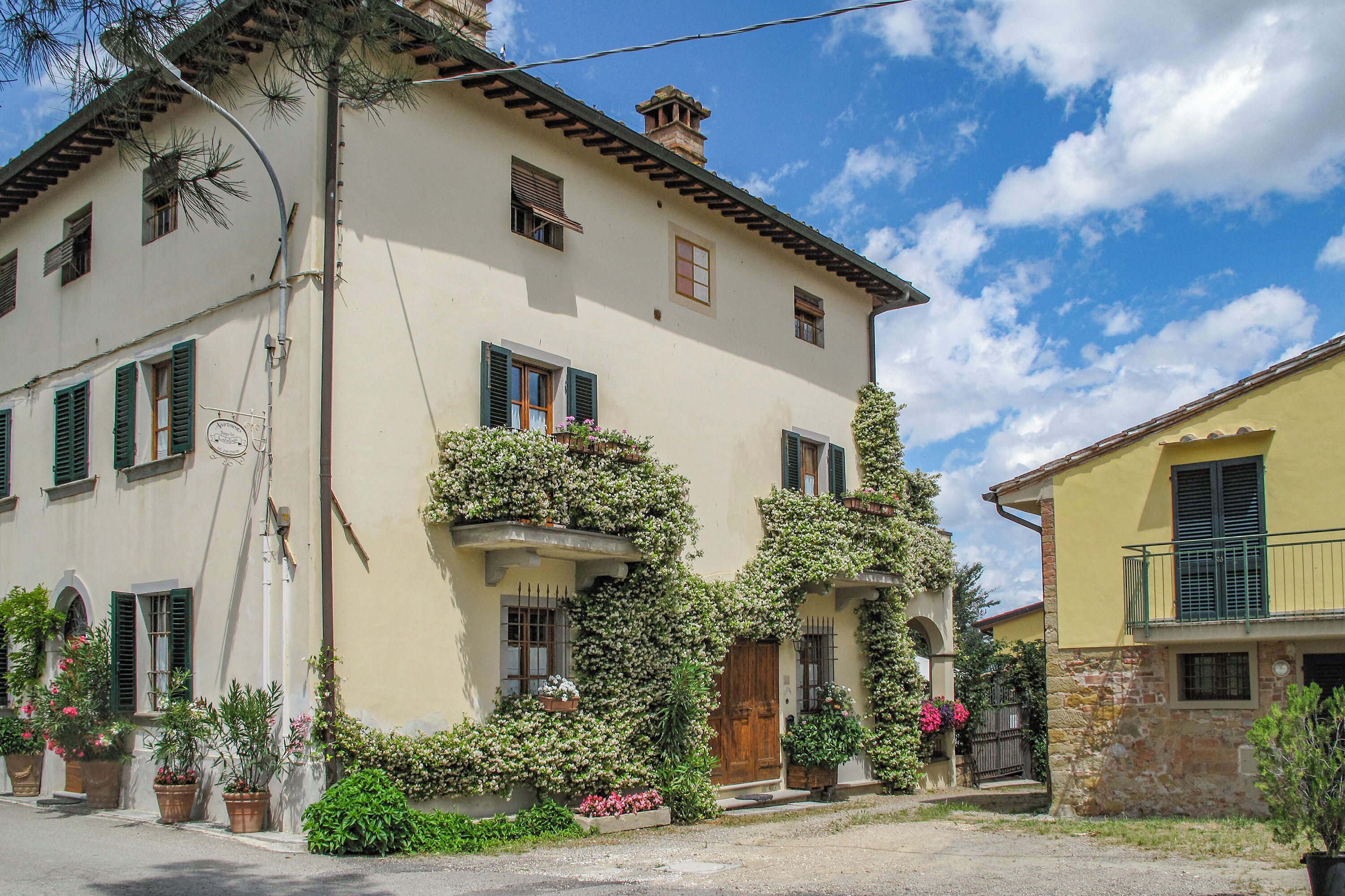 A two-story building with a balcony, a wooden door, and a window with shutters.
