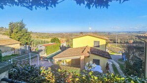 A yellow house with a tiled roof, surrounded by greenery and a clear sky. - Francigena Loggia Pergola Shared Pool (Gambassi Terme)