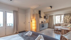 Ein Hotelzimmer mit Bett, Essbereich und einer Küchenzeile.