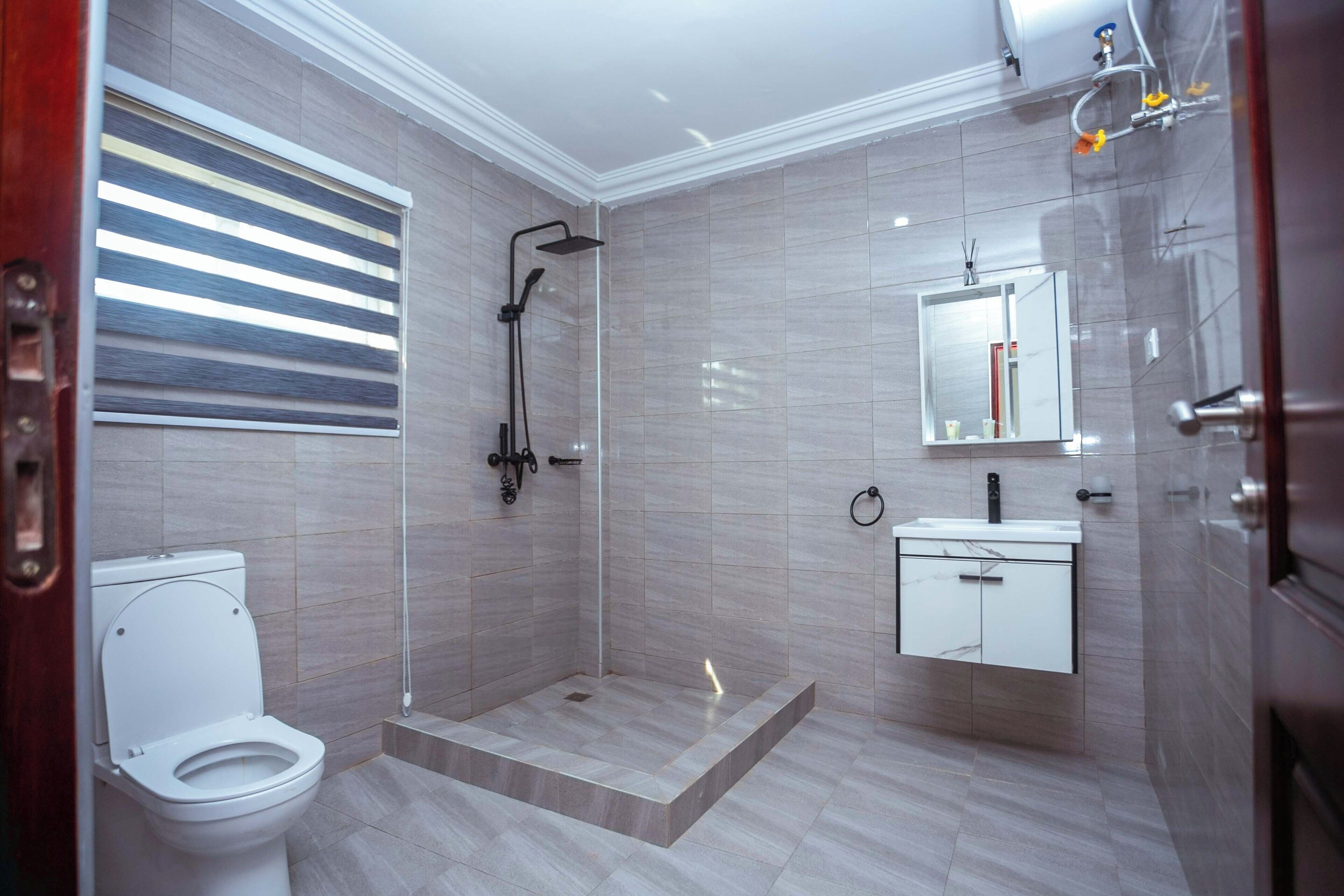 Une salle de bain moderne équipée d’une douche, de toilettes et d’un meuble-lavabo.