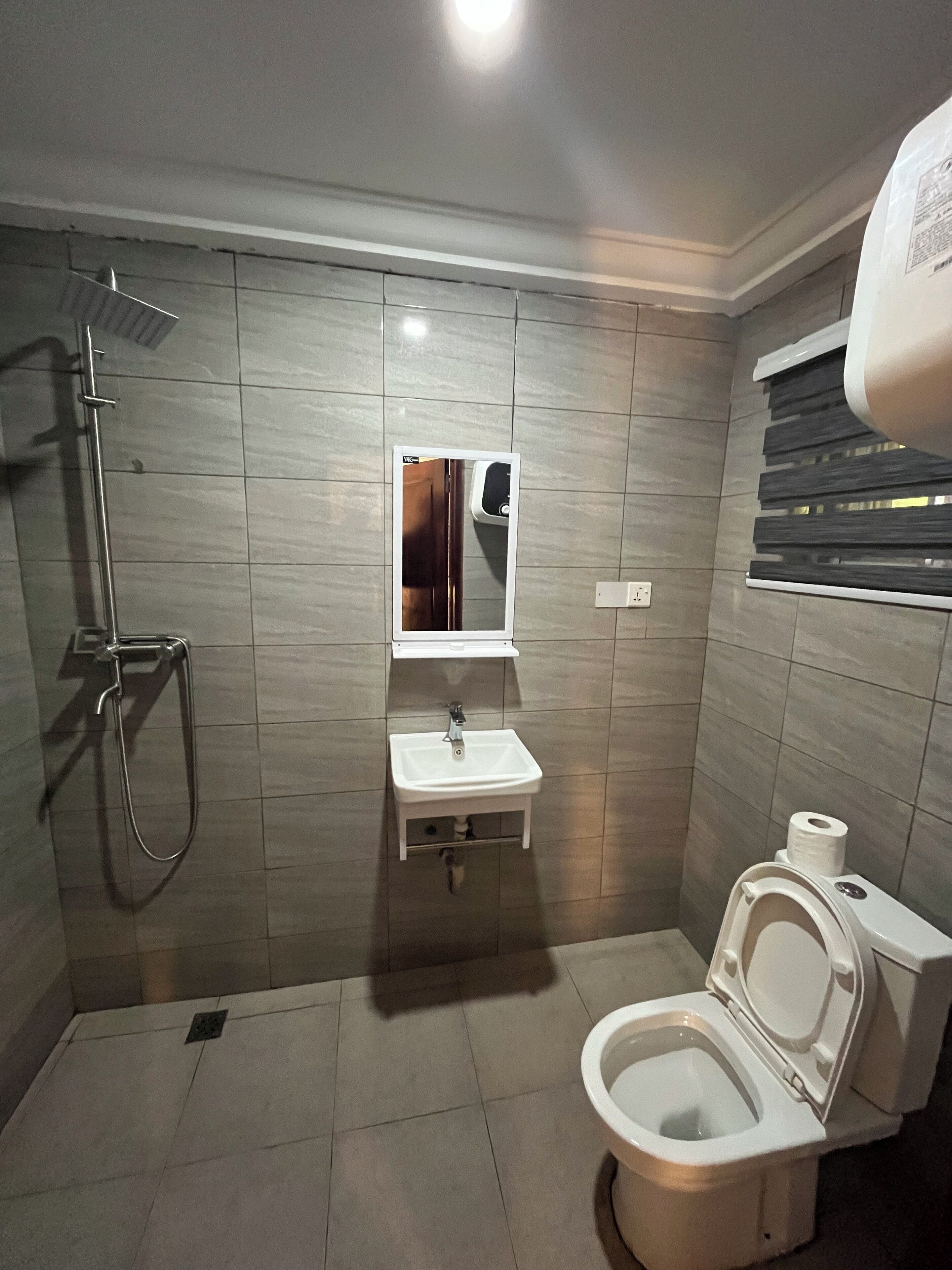 Ein kleines Badezimmer mit Toilette, Waschbecken und Dusche.