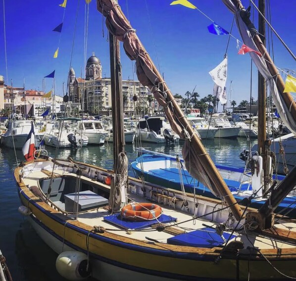 Boats docked at the marina, surrounded by buildings with a notable dome.