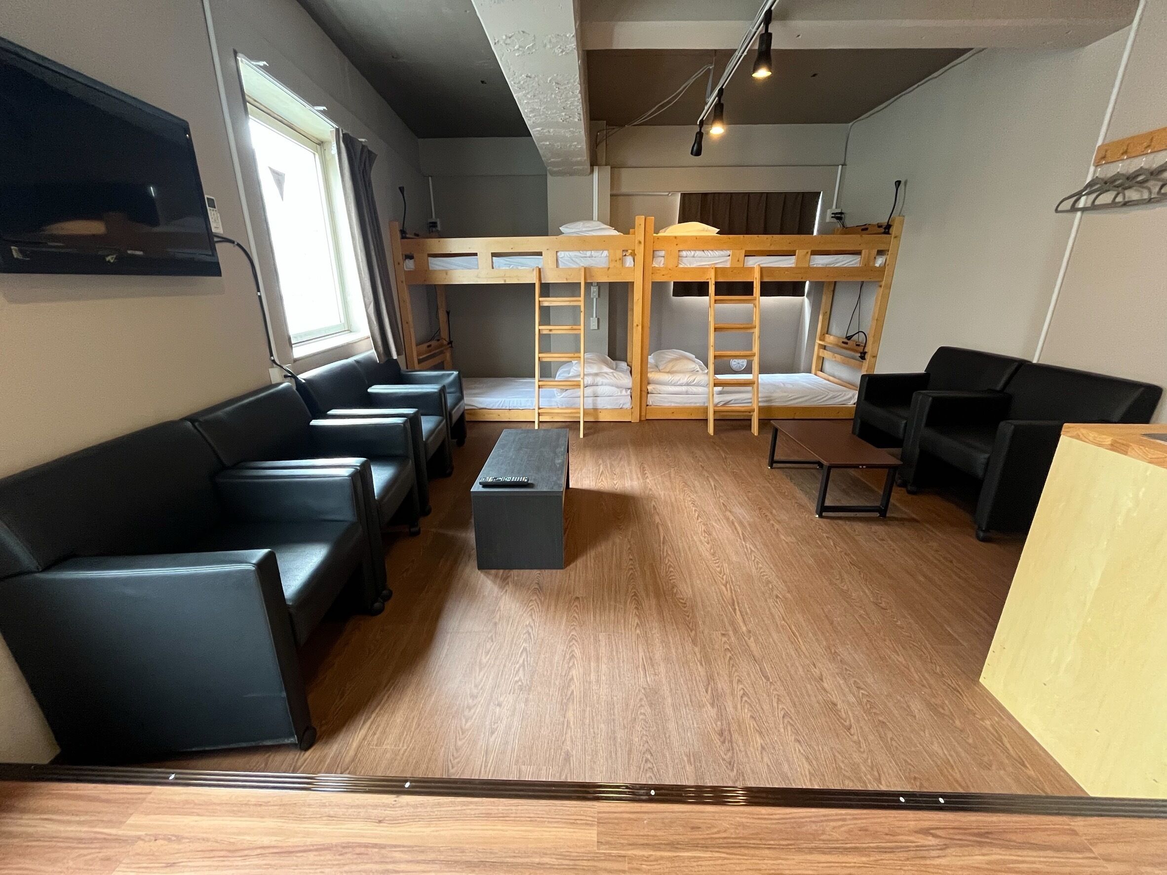 A room with bunk beds, a sofa, a coffee table, and a TV.