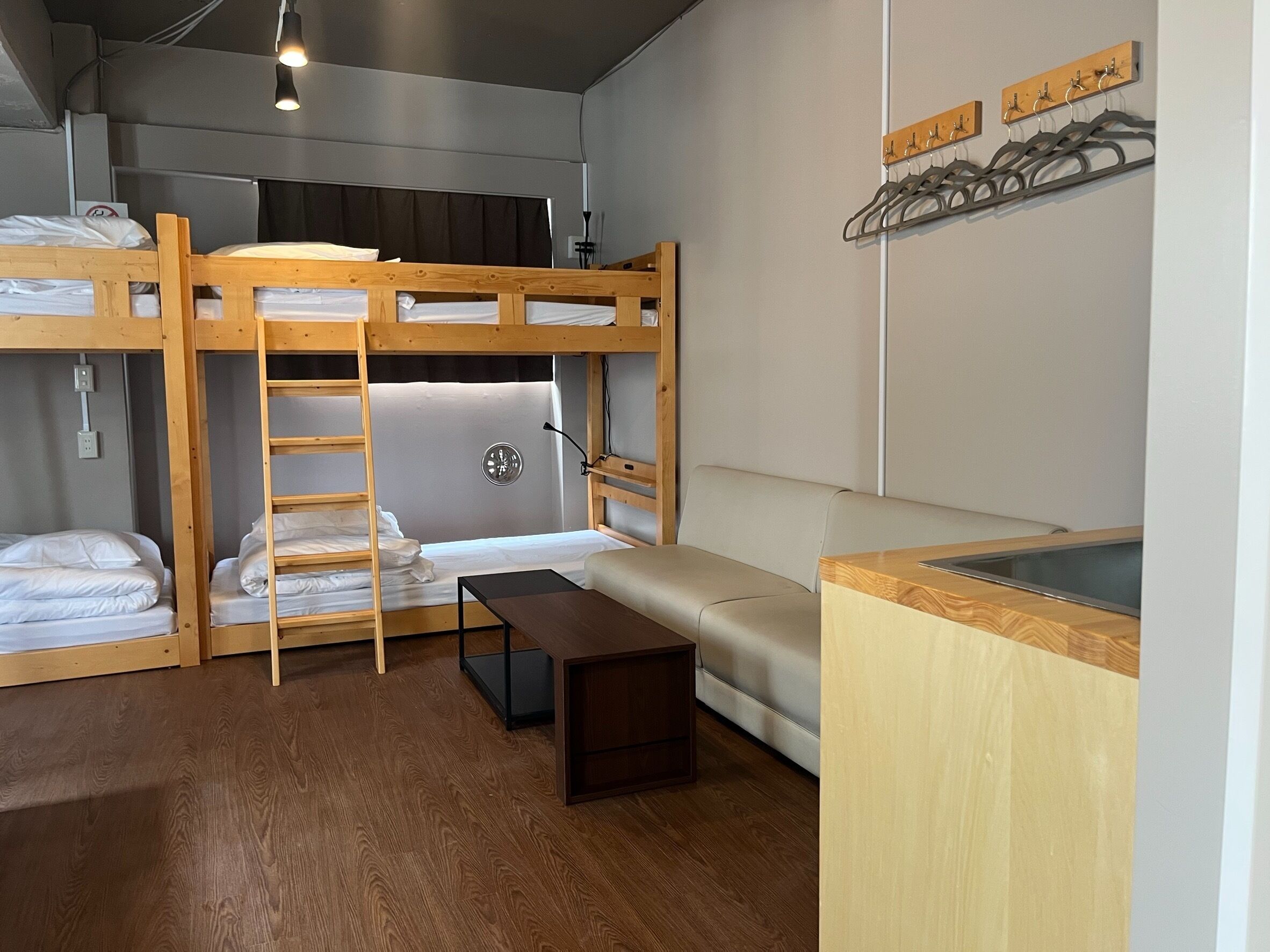 Habitación con literas, un escritorio y un banco.
