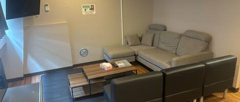 Una sala de estar moderna con un sofá modular, un televisor de pantalla plana y una mesa de centro.