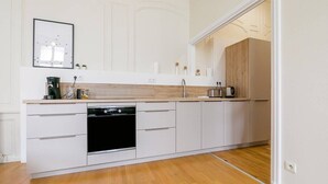 A modern kitchen with white cabinetry, a dishwasher, and a wooden countertop. - Le Bressey  Historic Mansion (Dijon)
