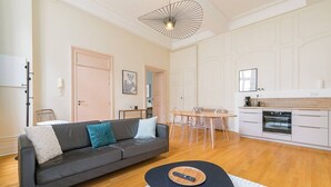 A modern living room with a sofa, a coffee table, and a dining area with a table and chairs. - Le Bressey  Historic Mansion (Dijon)