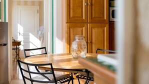 A kitchen with wooden cabinets, a round table, and chairs. - Le Panoramique - Exceptional View (Dijon)