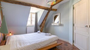 A bedroom with a bed, a hanging lamp, a window, a mirror, and a door. - Le Panoramique - Exceptional View (Dijon)