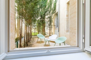 Enjoy the serene view of the surrounding trees and building from the comfort of this cozy room.