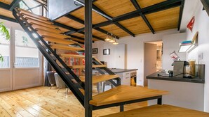 Um interior moderno com escada de madeira, área de jantar e cozinha.