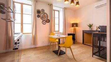 A modern kitchen with a dining table, chairs, and a hanging light fixture.