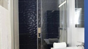 A modern bathroom with a glass shower enclosure, a white sink, and a large mirror. - La Chouette –  Cité Gastronomique (Dijon)