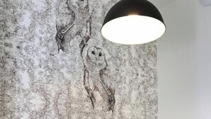 A dining area with a wooden table, blue cups, a kettle, and a wall with an owl mural. - La Chouette –  Cité Gastronomique (Dijon)