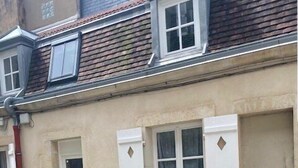 A house with a patio, a table, and chairs. - Le Duplex des Ducs- Au cœur du centre Historique- (Dijon)